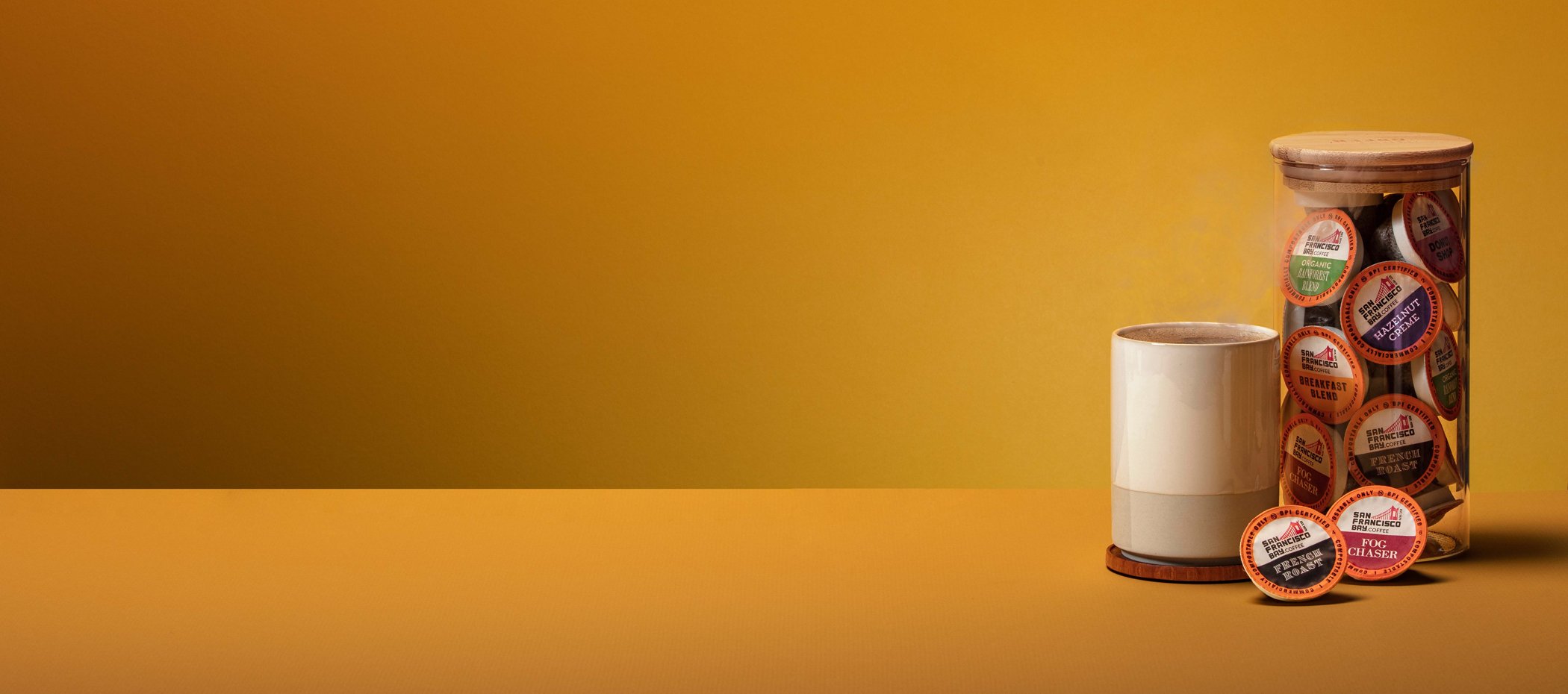 coffee pods in a glass jar beside a ceramic mug