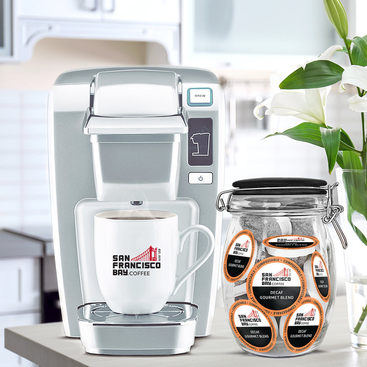 Decaf Gourmet Blend Coffee Pods in a Glass Jar with Coffee Maker and Logo Cup of San Francisco Bay Coffee